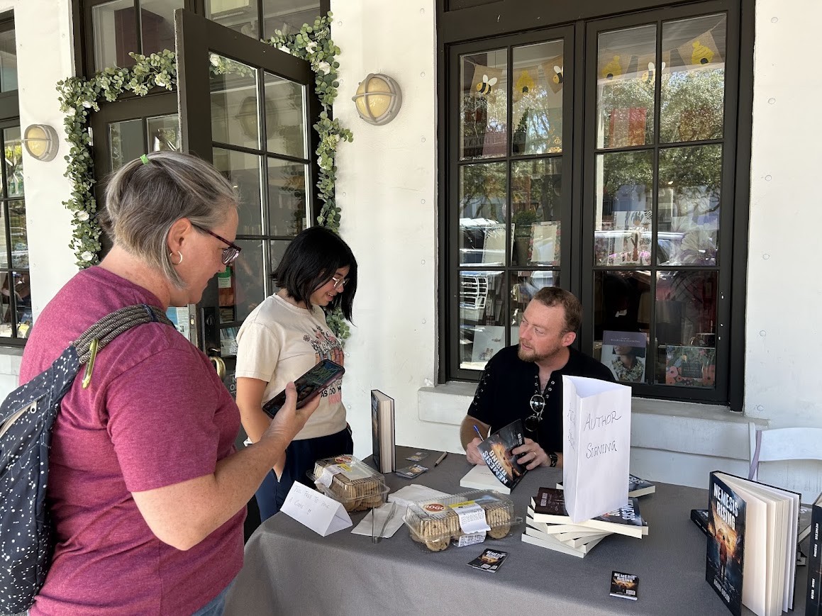 Adam signing copies of Nemesis Rising at an author event